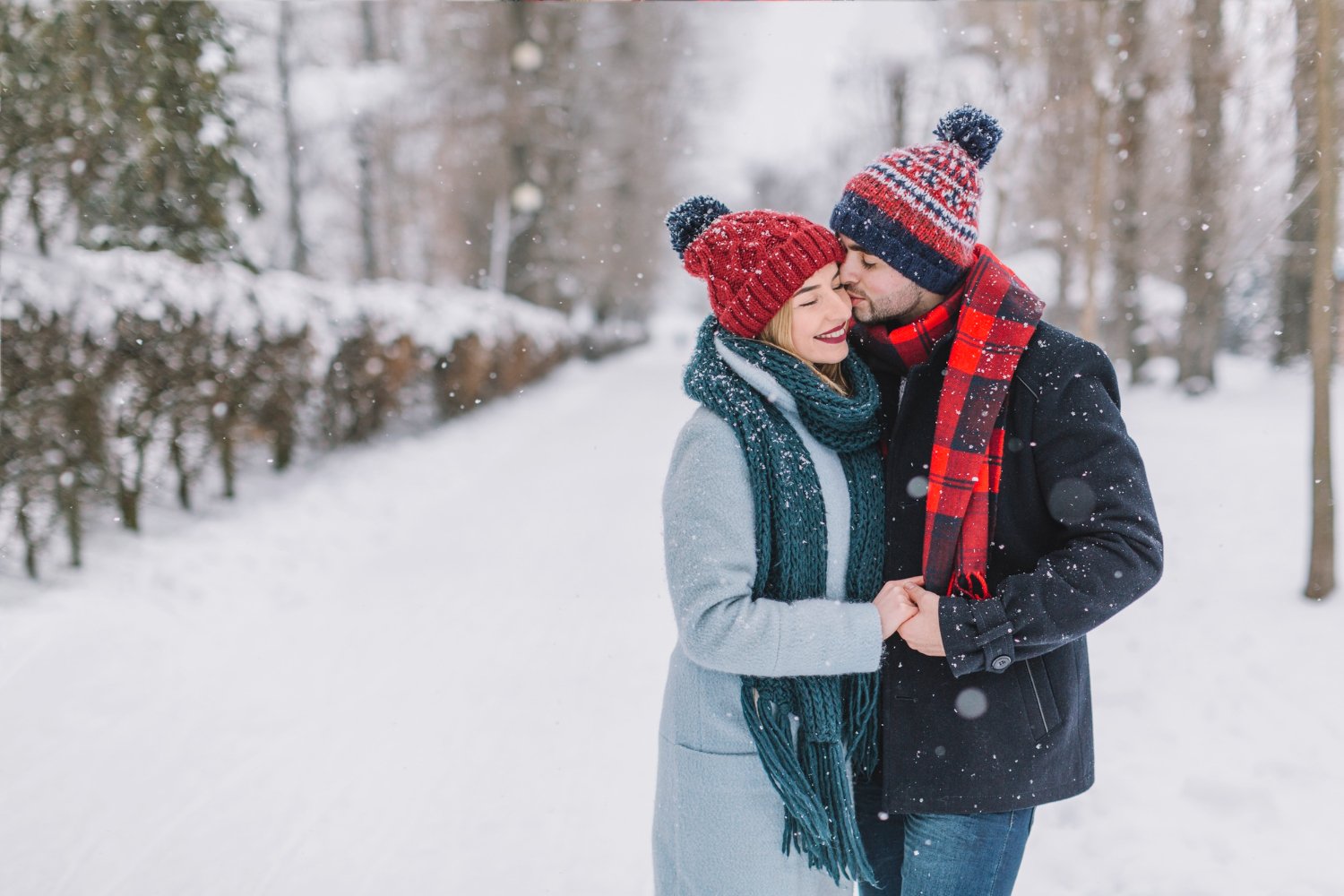 A couple in winter clothing standing in the snow, enjoying a romantic moment in Manali.